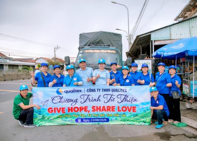 Qualitex team with the Give Hope, Share Love banner in front of the gift delivery truck, August 23, 2026
