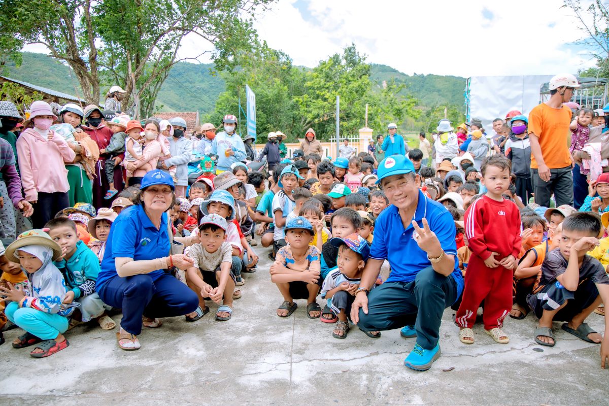 Qualitex team members with children and families gathered in Phu Tan Village, Dak Lak